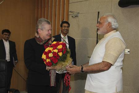 U.S. ambassador to India Nancy Powell (2nd L) receives a bouquet from Hindu nationalist Narendra Modi (R), prime ministerial candidate for India's main opposition Bharatiya Janata Party (BJP) and Gujarat's chief minister, during their meeting in Gandhinagar in the western Indian state of Gujarat February 13, 2014. REUTERS/Gujarat Information Department/Handout via Reuters