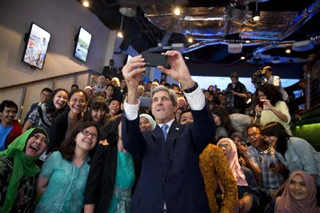 U.S. Secretary of State John Kerry (C) takes a selfie with a group of students before delivering a speech on climate change in Jakarta February 16, 2014. REUTERS/Evan Vucci/Pool