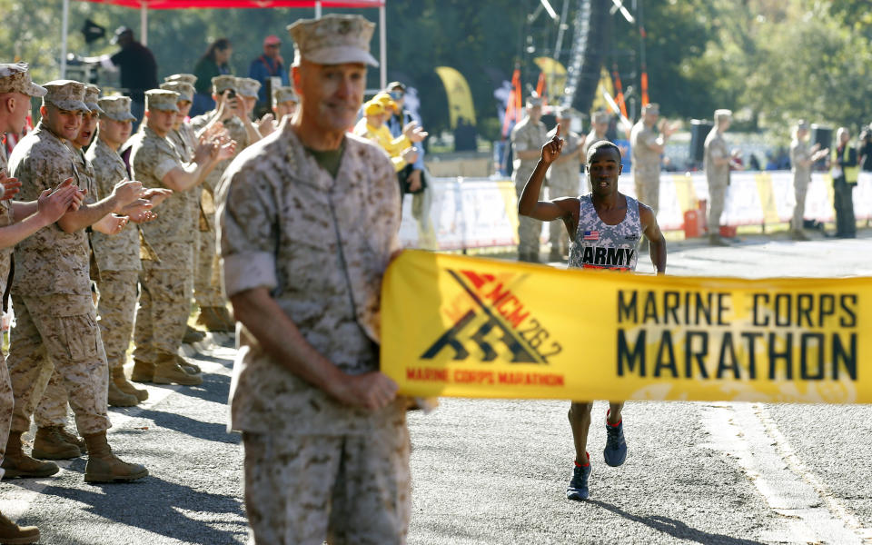 Samuel Kosgei, from Junction City, Kan., celebrates as he prepares to cross the finish line to be the first male finisher of the 39th Marine Corps Marathon, Sunday, Oct. 26, 2014 in Arlington, Va. The race includes runners from 59 nations and each branch of the U.S. armed forces.  (AP Photo/Alex Brandon)