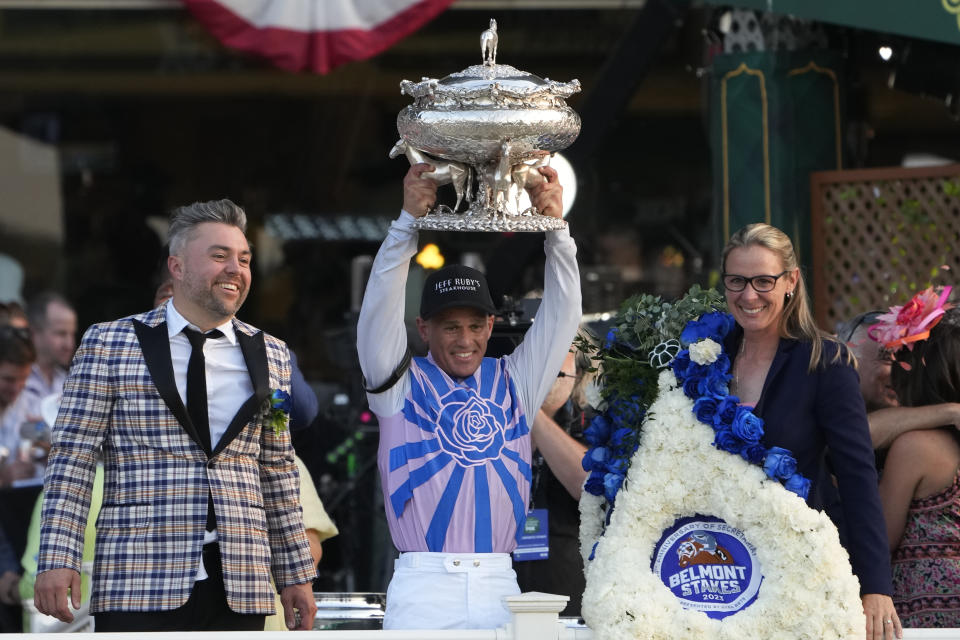 Jockey Javier Castellano, center, hoists up the August Belmont Trophy alongside owner Jon Ebbert, left, and trainer Jena Antonucci, right, after their horse Arcangelo won the 155th running of the Belmont Stakes horse race, Saturday, June 10, 2023, at Belmont Park in Elmont, N.Y. (AP Photo/Seth Wenig)