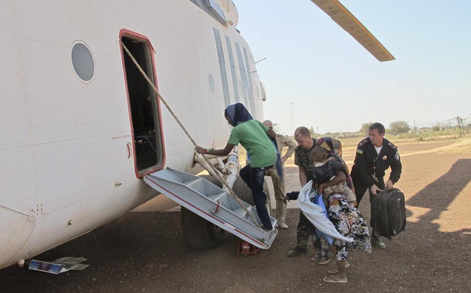 In this photo taken Tuesday, Dec. 24, 2013 and released by the United Nations Mission in South Sudan (UNMISS) on Wednesday, Dec. 25, 2013, nationals from Uganda, Kenya, Ethiopia and Eritrea are evacuated by UN helicopter to Juba from Bentiu, in oil-rich Unity state, in South Sudan. (AP Photo/UNMISS, Anna Adhikari)