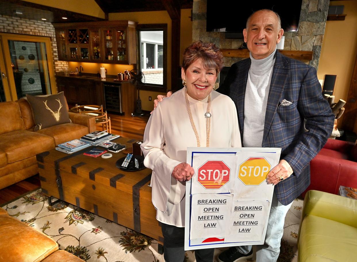 Jack and Louise Barron hold up the sign that they held during a 2018 meeting, which led to a Supreme Judicial Court decision in their favor.