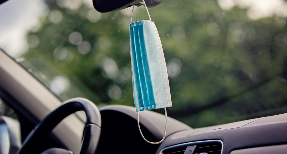 Face mask hanging from a rearview mirror.