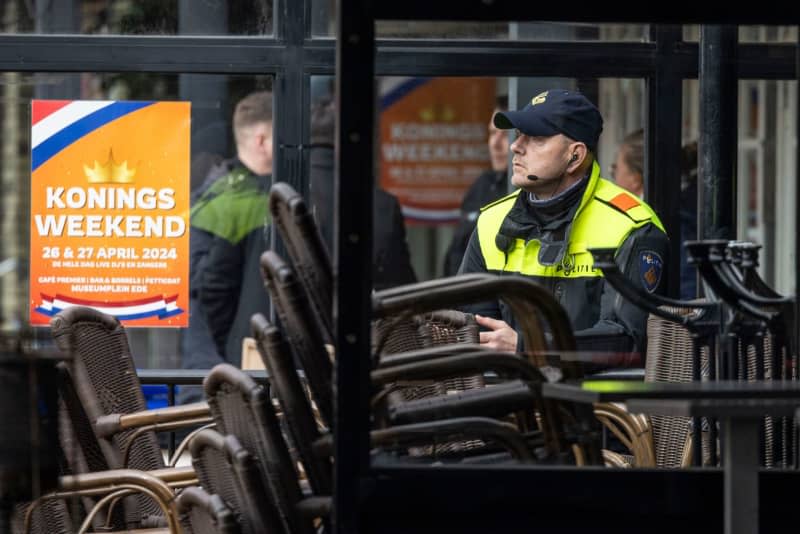 A police officer stands outside the "Petticoat" cafe while evidence is secured inside the building. In a hostage-taking that ended without bloodshed, four people were threatened with knives by a perpetrator known to the police. Christoph Reichwein/dpa