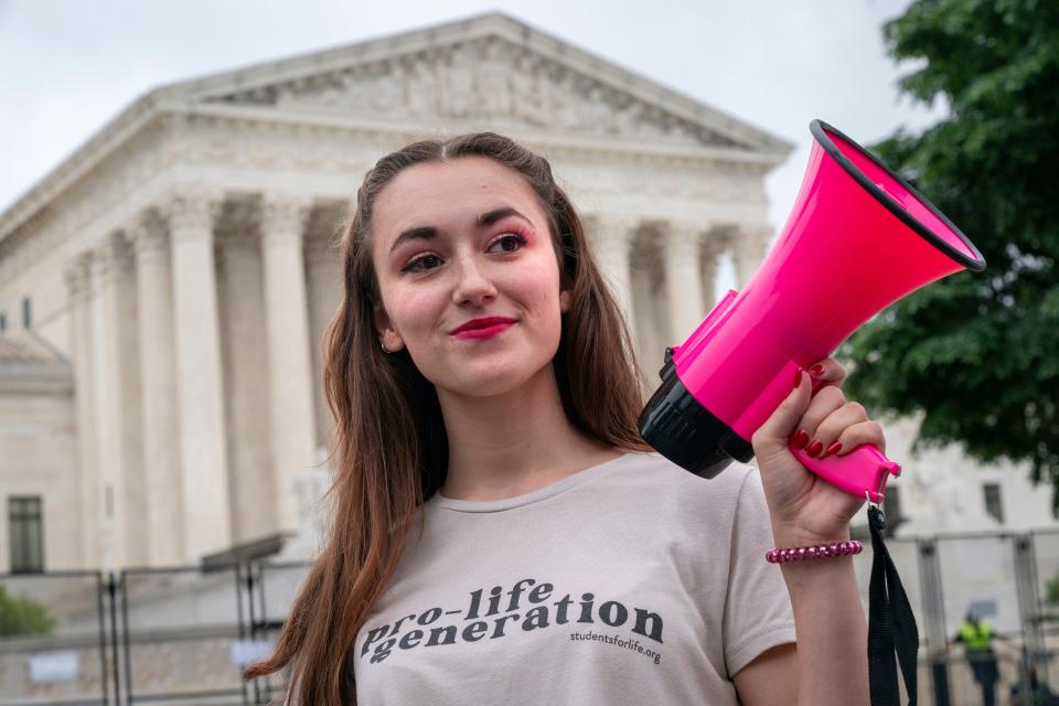 Grace Rykaczewski, 21, of Morristown, N.J., poses for a portrait as she demonstrates against abortion, Saturday, May 14, 2022, outside the Supreme Court in Washington. "Once it's overturned, for the pro-life movement this is only the beginning," said Rykaczewski, who goes by the handle, "Pro Life Barbie" on social media.