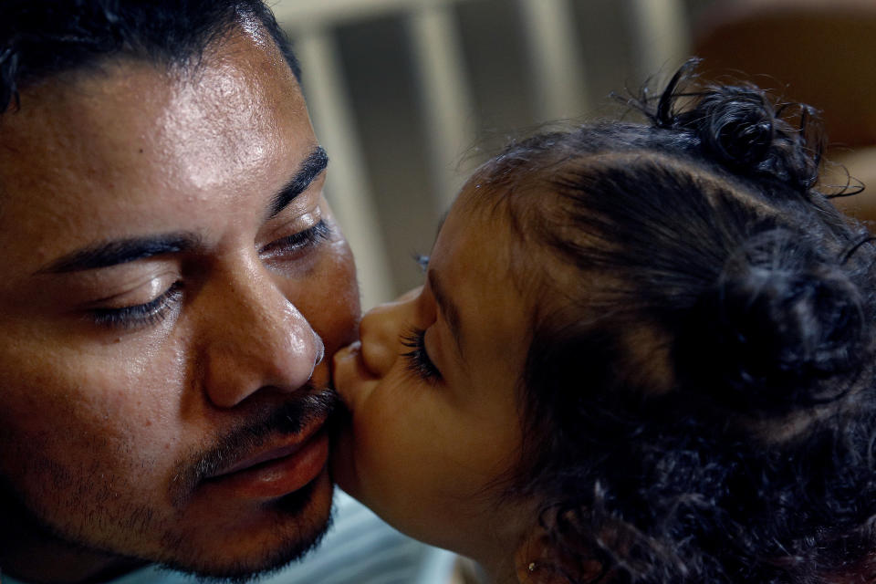 En esta foto del 28 de agosto del 2018, Luis Alberto Enamorado Gómez besa a su hija Jeydi, de 1 año, en su casa en Grandview, Missouri. Enamorado Gómez, que ha vivido en Estados Unidos desde el 2005, apela una orden de deportación derivada de un cargo de conducir en estado de ebriedad en el 2012, porque teme lo que su expulsión significaría para sus siete hijos, todos ciudadanos estadounidenses y de quien él es el único responsable. (AP Foto/Charlie Riedel)