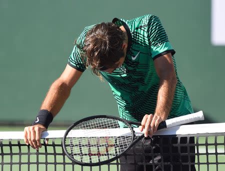 Mar 19, 2017; Indian Wells, CA, USA; Roger Federer (SUI) rests on the net after match point as he defeated Stan Wawrinka (not pictured) 7-6, 6-4 in the men's final in the BNP Paribas Open at the Indian Wells Tennis Garden. Mandatory Credit: Jayne Kamin-Oncea-USA TODAY Sports