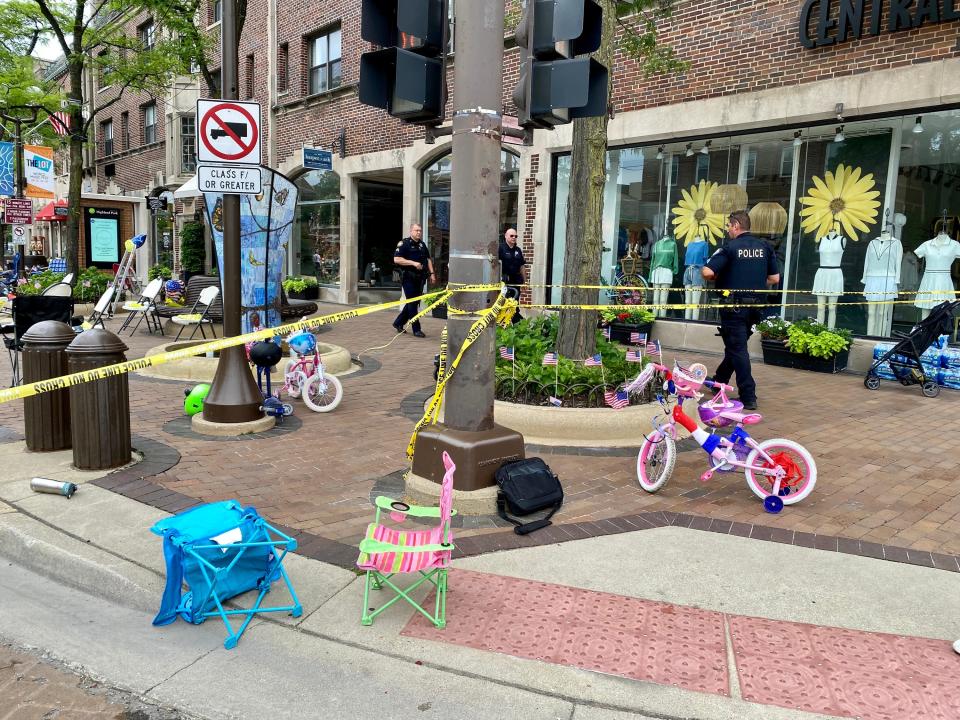 Law enforcement officers walk around a crime scene after a shooting at a parade on July 4, 2022, in Highland Park, Ill.