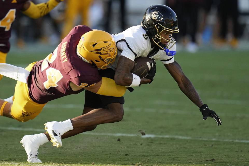 Colorado wide receiver Jimmy Horn Jr. (5) drags Arizona State linebacker Tate Romney (24) after making a catch during the first half of an NCAA college football game Saturday, Oct. 7, 2023, in Tempe, Ariz. (AP Photo/Ross D. Franklin)