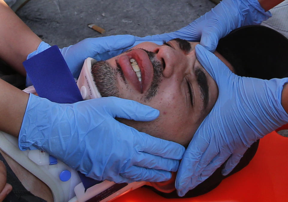 An anti-government protester receives treatment after he was attacked by Hezbollah supporters, in Beirut, Lebanon, Tuesday, Oct. 29, 2019. The violence came shortly after dozens of others, also wielding sticks, attacked a roadblock on a main Beirut thoroughfare set up by the protesters. (AP Photo/Hussein Malla)