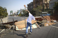 A protester throws a brick towards police during a protest against the military coup in Mandalay, Myanmar, Sunday, Feb. 28, 2021. In the month since Feb. 1 coup, the mass protests occurring each day are a sharp reminder of the long and bloody struggle for democracy in a country where the military ruled directly for more than five decades. (AP Photo)