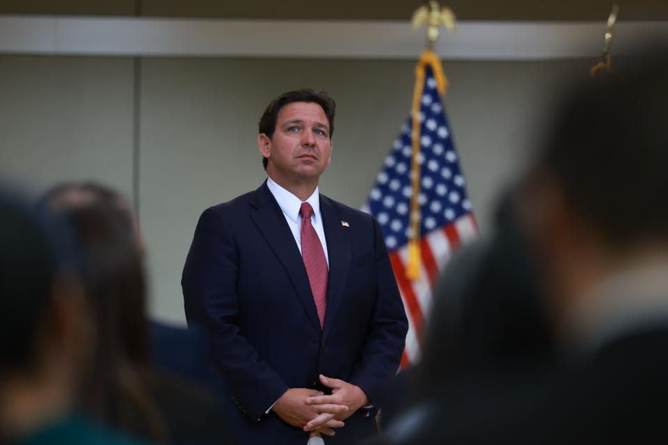Governor DeSantis stands in front of a crowd.