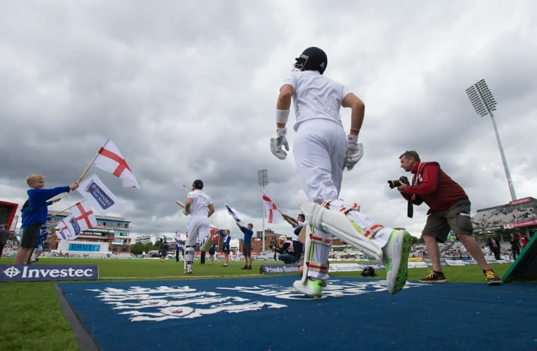 England's Alastair Cook and Joe Root run onto the pitch at the start of play on the 4th day of their 2nd Test match against Pakistan, at the Old Trafford Cricket Ground in Manchester, on July 25, 2016