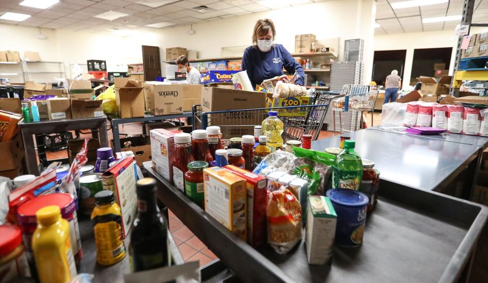 Pantry volunteer Lois Ronca packs dry goods into a box at the Fondy Food Pantry in Fond du Lac.