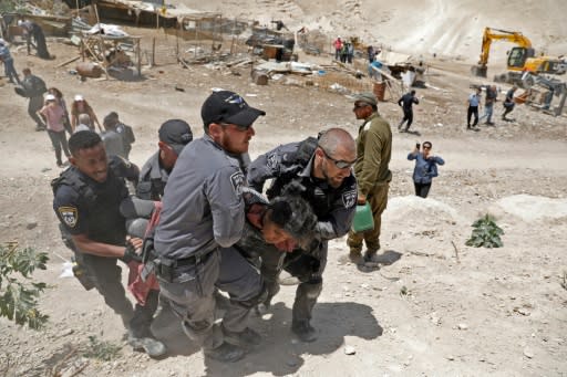 Israeli security forces arrest a young demonstrator in the Palestinian Bedouin village of Khan al-Ahmar in the occupied West Bank on July 4, 2018