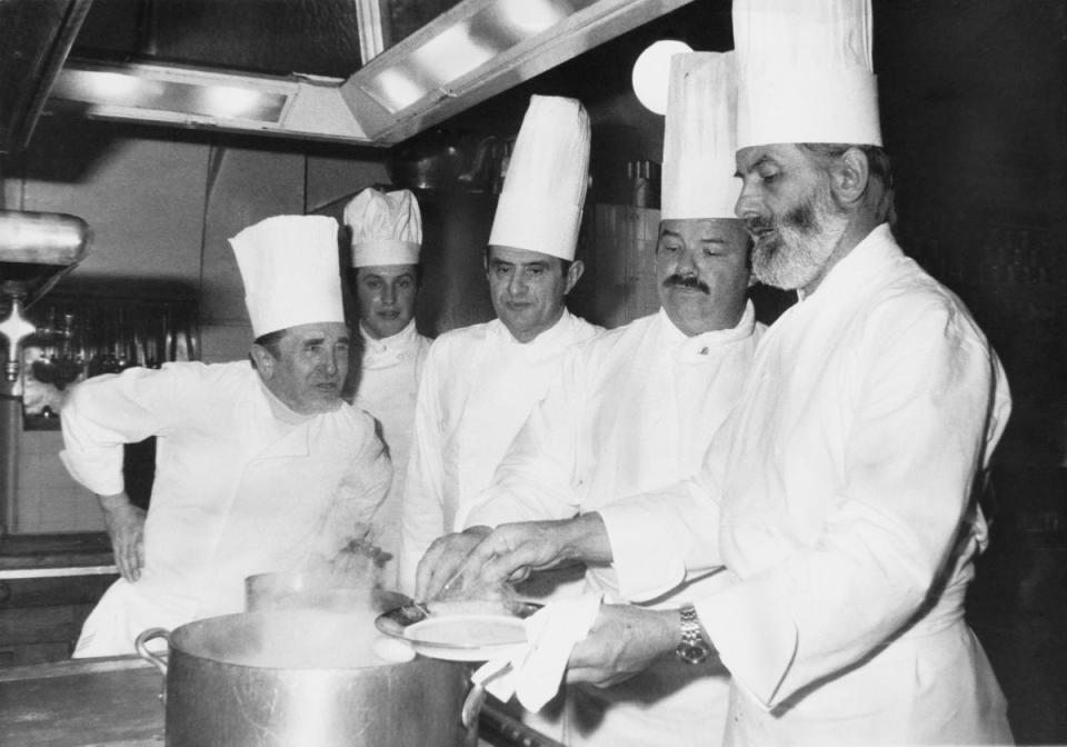 French chef Paul Bocuse (center) in the kitchens of the Elysee Palace, Paris, after being awarded the Legion of Honour by President Valery Giscard d’Estaing, on 25 February 1975. He is helping to prepare a presidential dinner with (left to right) Marcel Le Servot, Chef de cuisine at the Elysee Palace, Mathias Thery, Pierre Troisgros, and Jean Troisgros (Photo by Agence France Presse/Getty Images)