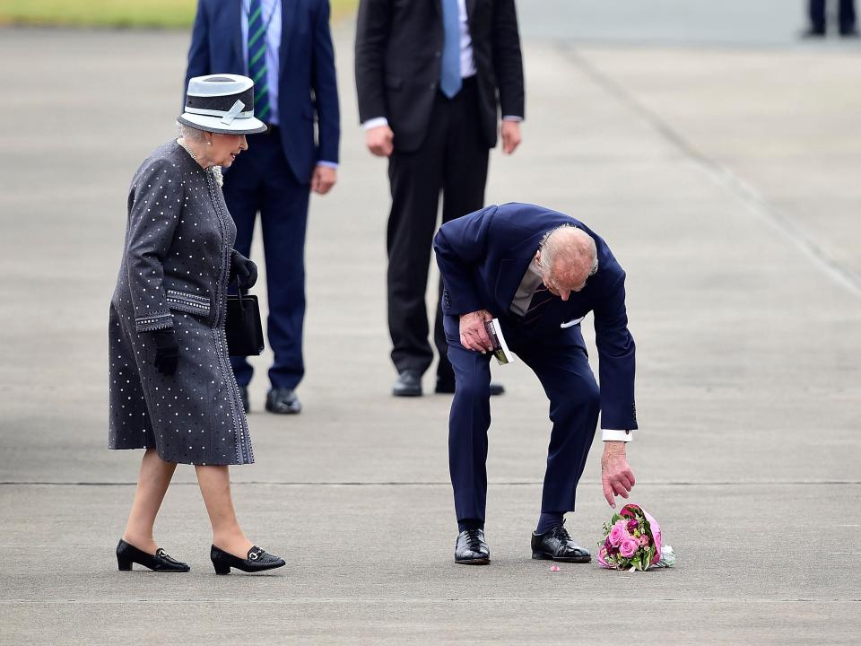 Prince Philip picks up a dropped bouquet of flowers in 2015.