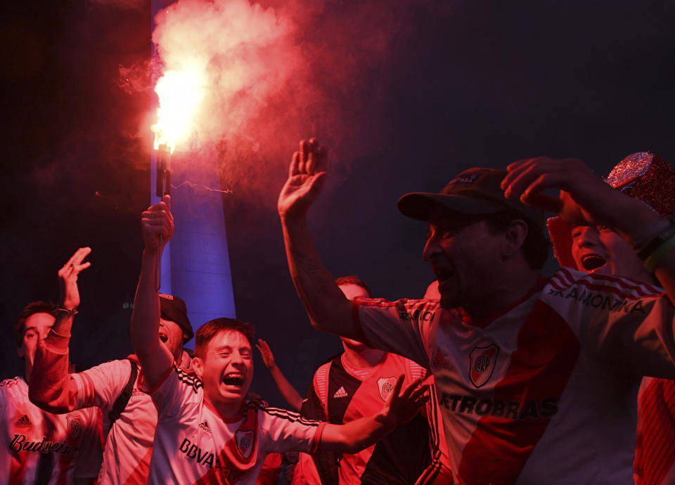 River Plate soccer fans light flares as they celebrate defeating Boca Juniors 3-1 and clenching the Copa Libertadores championship title, at the Obelisk in Buenos Aires, Argentina, Sunday, Dec. 9, 2018. The South American decider was transferred from Buenos Aires to Madrid, Spain after River fans attacked Boca's bus on Nov. 10 ahead of the second leg. (AP Photo/Gustavo Garello)