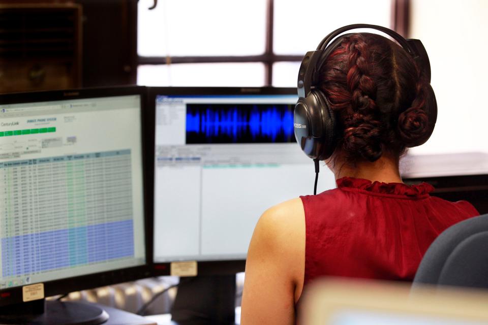 A witness protection analyst with the Milwaukee County District Attorney's Office listens to jail calls in 2015.