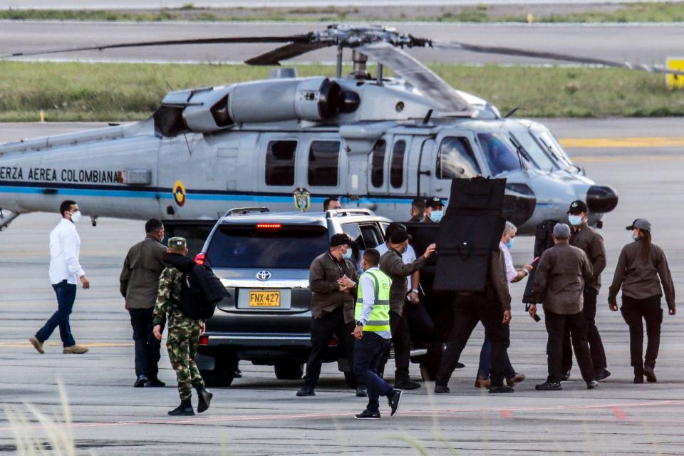 Colombia's President Ivan Duque (4-R) walks surrounded by bodyguards close to the presidential helicopter at the tarmac of the Camilo Daza International Airport after it was hit by gunfire in Cucuta, Colombia on June 25, 2021. - Colombian President Ivan Duque said Friday the helicopter he was flying in near the border with Venezuela was hit by gunfire. 