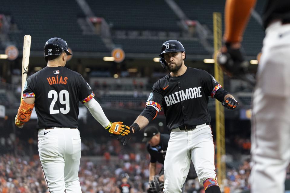 Baltimore Orioles' Colton Cowser, right, celebrates with Ramon Urias (29) after hitting a home run against the Texas Rangers during the fourth inning of a baseball game Friday, June 28, 2024, in Baltimore. (AP Photo/Stephanie Scarbrough)