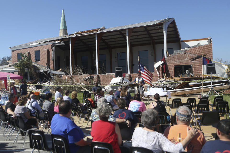 The Rev. John Blount leads a church service outside of St. Andrew United Methodist Church in Panama City, Florida on Sunday, Oct. 14, 2018. A small group gathered for the weekly Sunday service despite the substantial damage the church received during Hurricane Michael. [Patti Blake/Northwest Florida Daily News via AP)