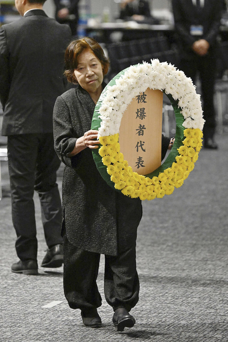 Takeko Kudo, representing atomic bomb victims, walks over to lay a wreath during a ceremony to mark the 78th anniversary of the atomic bombing in Nagasaki, southern Japan, Wednesday, Aug. 9, 2023. Nagasaki marked the 78th anniversary of the the U.S dropping an atomic bomb on the city Wednesday, with its mayor urging nuclear states and those under their nuclear umbrella, including Japan, to not justify nuclear weapons for deterrence and go for abolishing. (Kyodo News via AP)