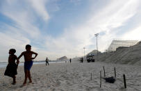 Children walks near a part of a mutilated body near the construction site of the beach volleyball venue for 2016 Rio Olympics on Copacabana beach in Rio de Janeiro, Brazil, June 29, 2016. REUTERS/Sergio Moraes