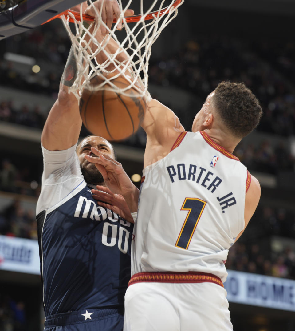 Dallas Mavericks center JaVale McGee, back, dunks the ball for a basket as Denver Nuggets forward Michael Porter Jr. defends in the first half of an NBA basketball game Wednesday, Feb. 15, 2023, in Denver. (AP Photo/David Zalubowski)