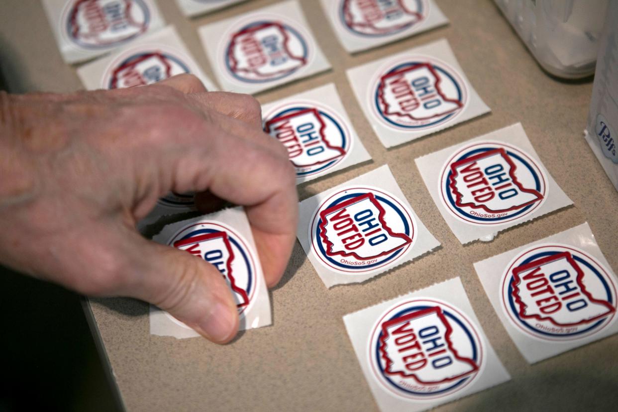 A poll worker carefully lays out "Ohio Voted" stickers for early voters to take after casting their ballots on November 2, 2023 for the upcoming November 7 Ohio elections in Chillicothe, Ohio.