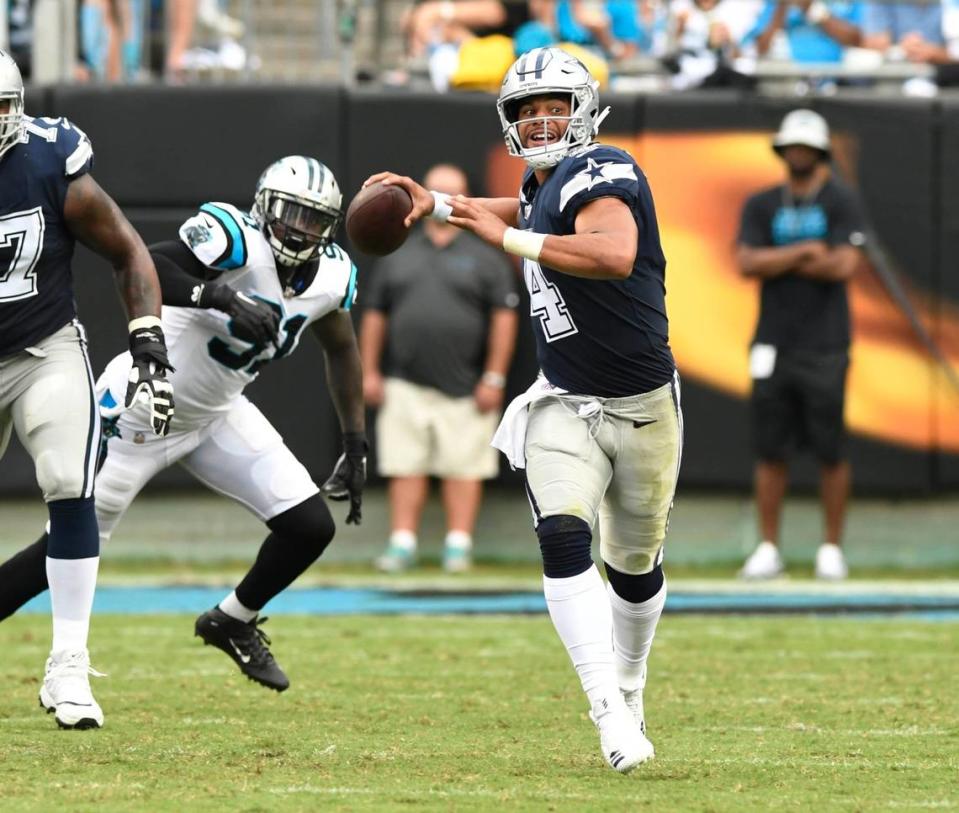 Dallas Cowboys quarterback Dak Prescott (4) rolls out to pass as he gets pressure from the Carolina Panthers defense at Bank of America Stadium on Sunday, September 9, 2018.