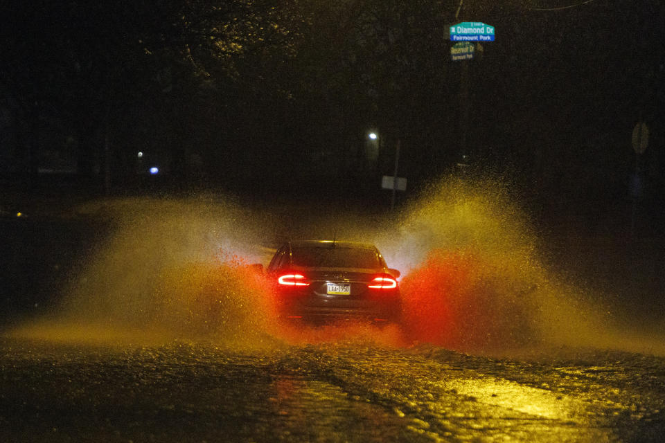 A car drives on a flooded street in Philadelphia early Monday, Dec. 18, 2023. (Alejandro A. Alvarez/The Philadelphia Inquirer via AP)