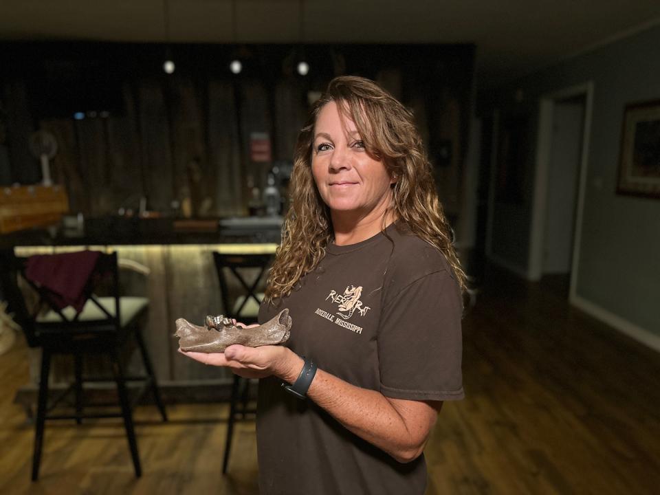 Sherry Coy of Rosedale holds up a jawbone from a sharp-toothed cat she found while searching for fossils. The giant cats became extinct about 11,000 years ago, and the jawbone is the first documented in Mississippi.