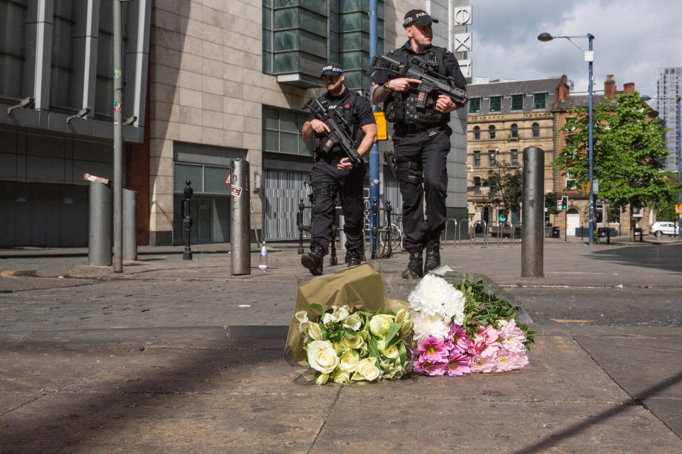 &nbsp;Armed police patrol on Shudehill walking past the first floral tributes to the victims of the terrorist attack in Manchester, England.&nbsp;