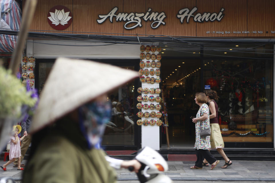 In this Feb. 21, 2019, photo, traffic passes a shop in Hanoi, Vietnam. The Vietnamese capital once trembled as waves of American bombers unleashed their payloads, but when Kim Jong Un arrives here for his summit with President Donald Trump he won’t find rancor toward a former enemy. Instead, the North Korean leader will get a glimpse at the potential rewards of reconciliation. (AP Photo/Hau Dinh)