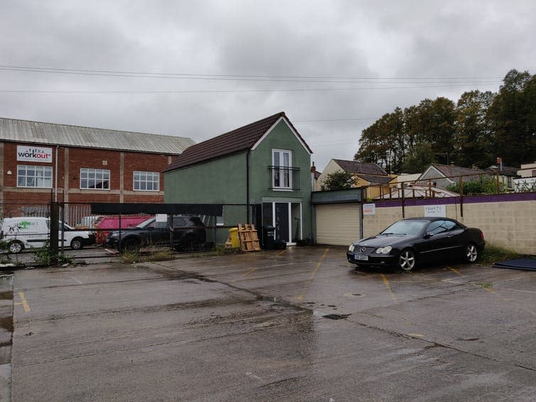 Car park and house under grey sky