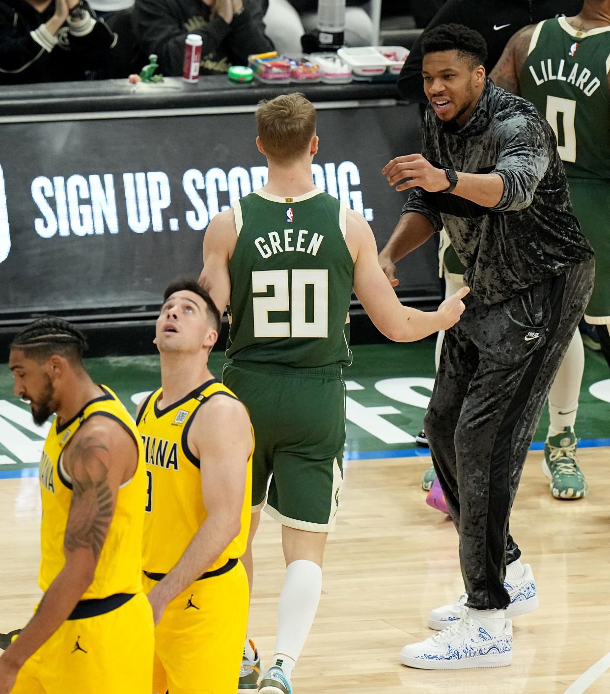 Giannis Antetokounmpo talks with Bucks guard AJ Green during their playoff game with the Pacers on Tuesday at Fiserv Forum.