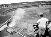 Australian athlete Ron Clark, bottom left, plunges the Olympic torch into the bronze bowl, to light the Olympic flame, which will burn throughout the XVI Olympic Games, in Melbourne, Australia, Nov. 22, 1956. (AP Photo)