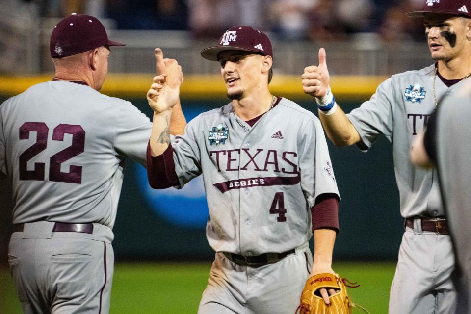 Texas A&M center fielder Travis Chestnut (4) congratulates teammates after the team's defeat of Kentucky during the College World Series at Charles Schwab Field Omaha.