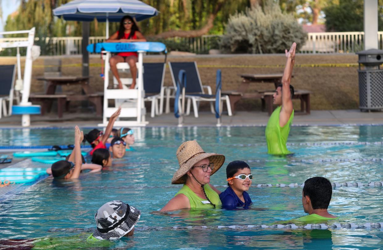 YMCA staff, in green shirts, supervise children swimming at the Palm Desert Aquatic Center in Palm Desert, Calif., Oct. 13, 2023. The aquatic center has been staffed by the local YMCA since it opened in 2011.