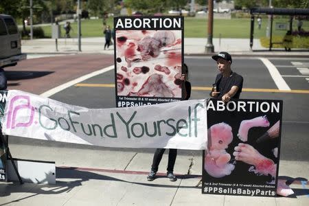 Activists hold signs as they rally against abortion outside City Hall in Los Angeles, California September 29, 2015. REUTERS/Mario Anzuoni