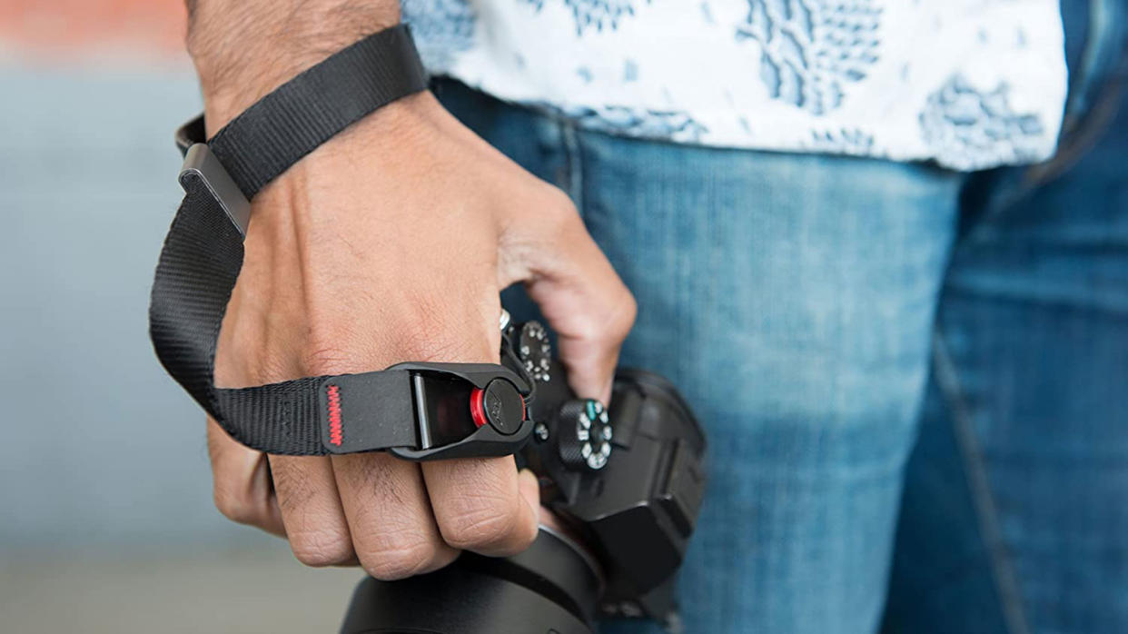  man's hand with best camera wrist strap round wrist holding a camera 