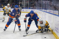 Pittsburgh Penguins Evan Rodrigues (9) battles for control of the puck against the New York Islanders' Matt Martin (17) and Cal Clutterbuck (15) in the third period of an NHL hockey game, Friday, Nov. 26, 2021, in Elmont, N.Y. (AP Photo/Eduardo Munoz Alvarez)