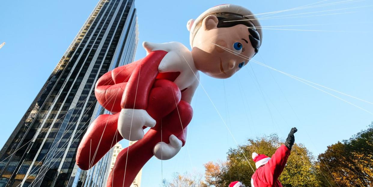 elf on the shelf giant balloon of an elf on the shelf going through a city