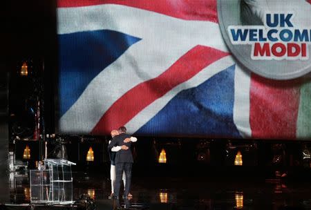 India's Prime Minister Narendra Modi embraces Britain's Prime Minister David Cameron on stage during an event at Wembley Stadium, in London, November 13, 2015. REUTERS/Suzanne Plunkett