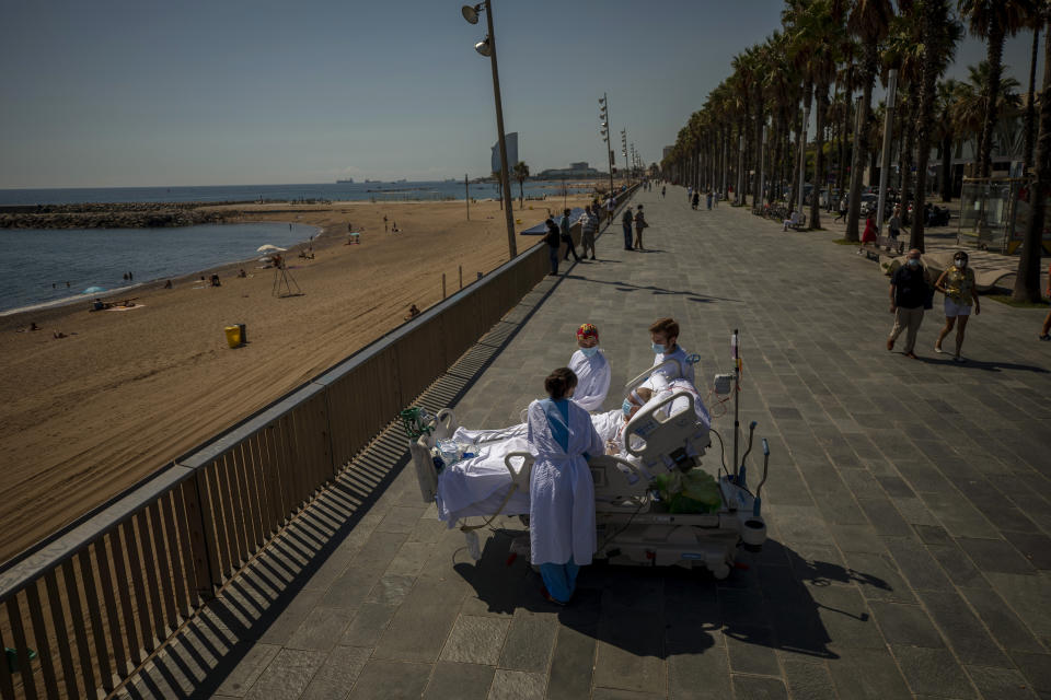 Francisco Espana, 60, is surrounded by members of his medical team as he looks at the Mediterranean sea from a promenade next to the "Hospital del Mar" in Barcelona, Spain, Friday, Sept. 4, 2020. Spain has become the first western Europe to accumulate more than 1 million confirmed infections as the country of 47 million inhabitants struggles to contain a resurgence of the coronavirus. (AP Photo/Emilio Morenatti)