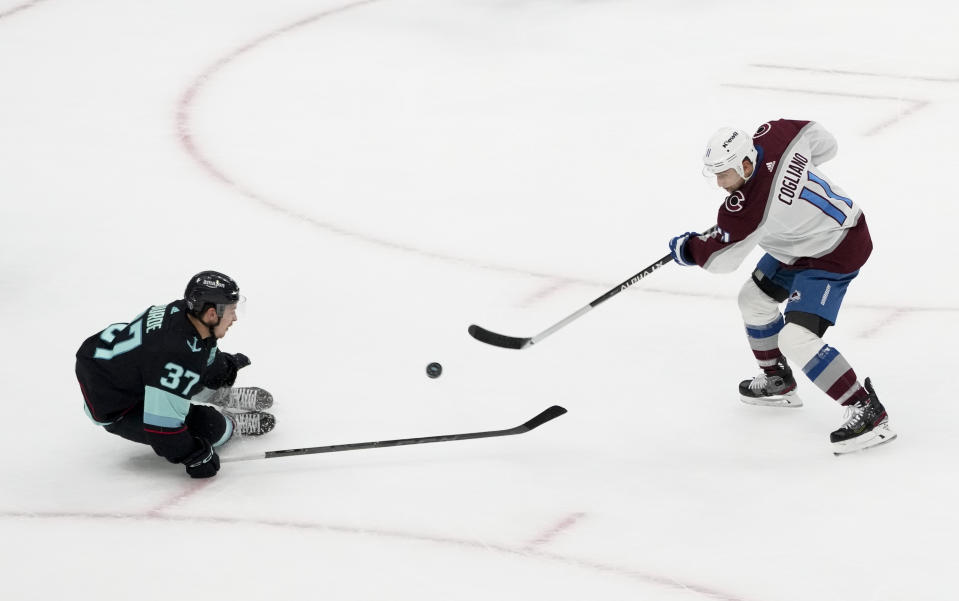 Colorado Avalanche center Andrew Cogliano (11) shoots past Seattle Kraken center Yanni Gourde (37) during the third period of Game 4 of an NHL hockey Stanley Cup first-round playoff series Monday, April 24, 2023, in Seattle. (AP Photo/Lindsey Wasson)