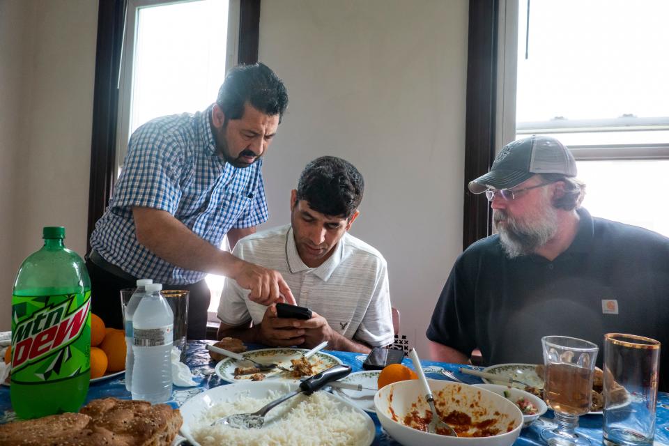 Azizullah Azizyar (center), Matt Coburn (right) and Mohammad Sadiq Alizada (left) help sort out his utility bill.