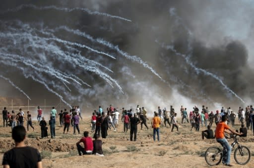 A picture taken on August 17, 2018 shows tear gas canisters fired by Israeli forces raining down on Palestinian protesters during a demonstration along the border of the Gaza Strip