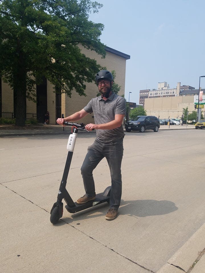 A file photo of Green Bay Mayor Eric Genrich riding a Bird electric scooter. Genrich followed recommendations and wore a helmet.